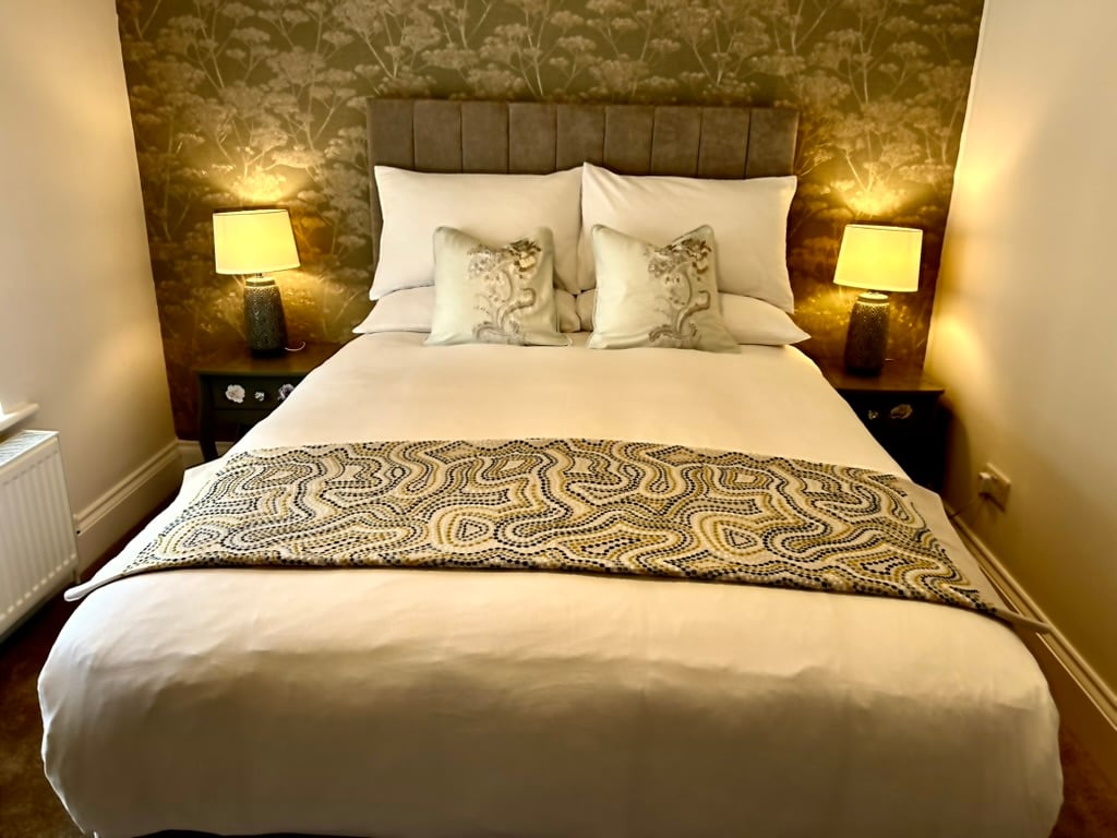 Prepared double bed with comfortable bedding and bedside lamps