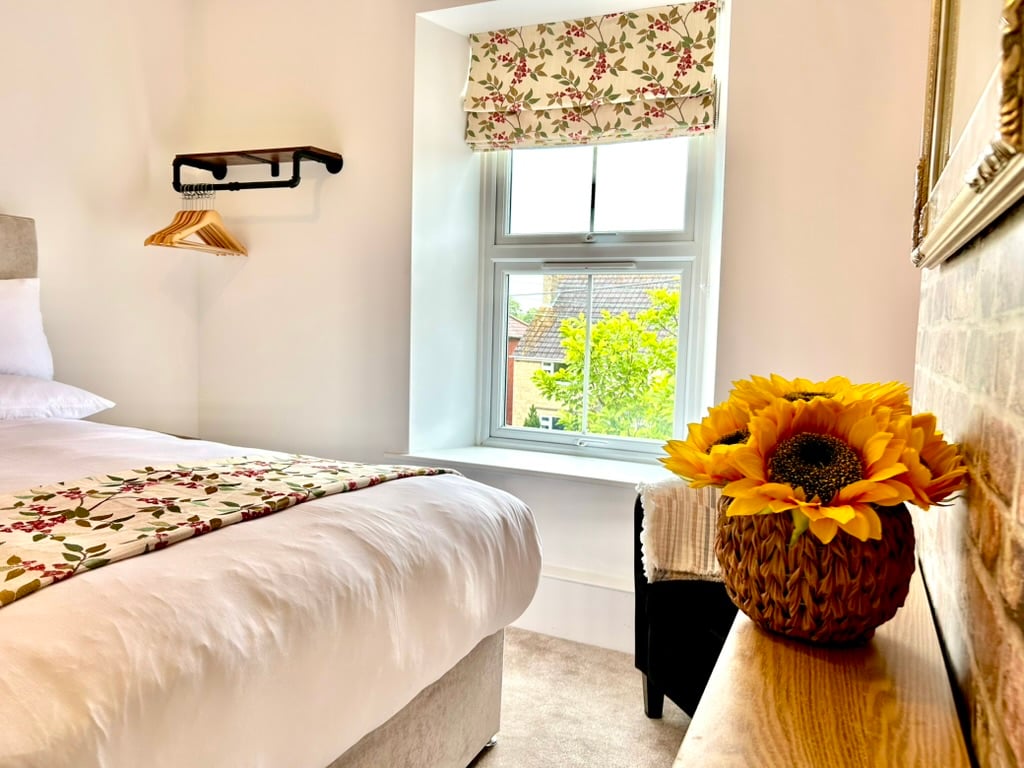 Double bedroom with floral accents and a bright window